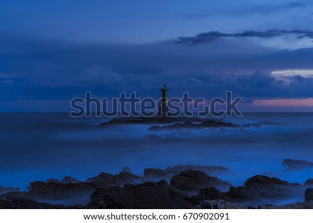 Beautiful nature and landscape photo of Adriatic Sea in Croatia at dusk. Colorful blue summer evening and a small lighthouse. Nice calm outdoors picture.