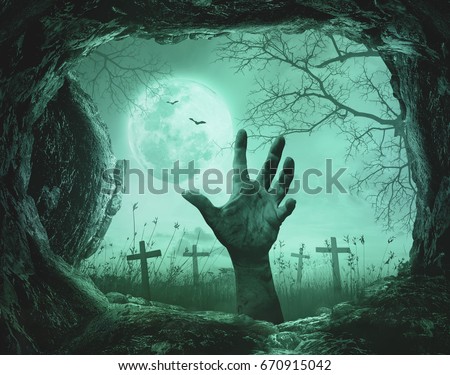 Halloween concept: Scary hand in cave stone on death tree with creepy cemetery background