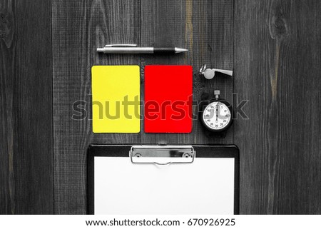 Referee tools. Yellow and red referee cards, whistle, stopwatch, pad, pen on wooden background top view copyspace