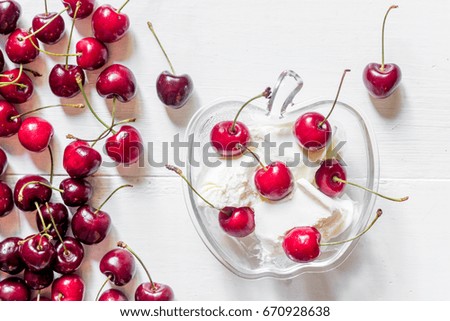 Ice cream decorated with fresh cherry on white table background top view