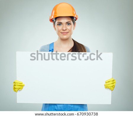 Smiling woman builder holding white banner. Isolated portrait.
