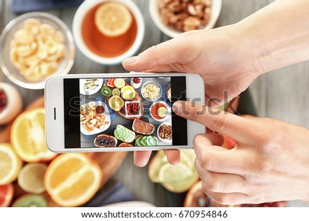 Female hands taking pictures of breakfast on table