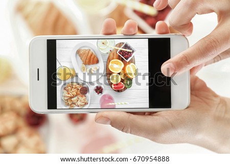 Female hands taking pictures of tasty breakfast on table