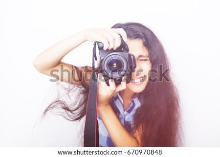 Cute brunette little girl holding an photo camera on white background