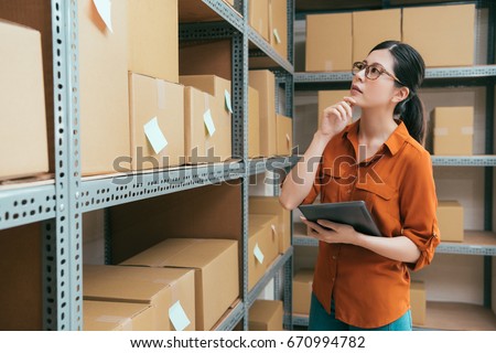 vintage retro film color photo of professional beauty lady working on online shopping company warehouse and holding mobile computer pad searching order box.