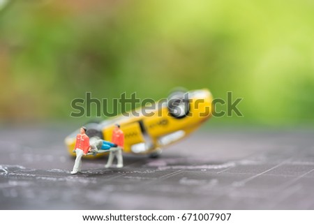 Miniature people, emergency medical team at work at accident scene, car crash, on world map. Concept of health care, emergency, life insurance, accident background
