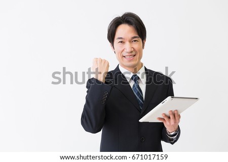 Asian middle age businessman who uses  tablet computer,