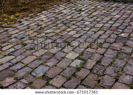 perspective view of a stone paving slab on the land of a street road. The old broken pavement path with cracks. Vintage style of the pavement path