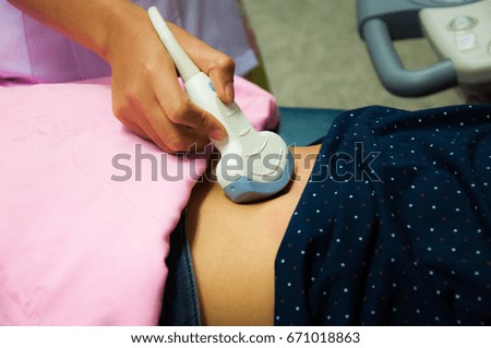 Medicine doctor working with ultrasound machine scan abdomen of patient in examination room in the hospital.