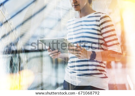 Double exposure. Young business woman stands and uses tablet computer. Hipster girl is blogging, chatting, checking email, browsing internet, working. Student learning online. Social media, network.