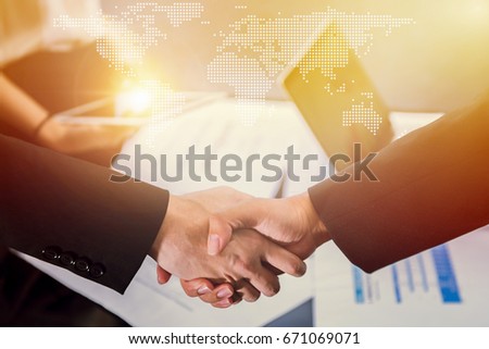Closeup of business people handshake greeting deal of world global international trade and export concept with world global cartography globalization, business people finishing up a meeting.