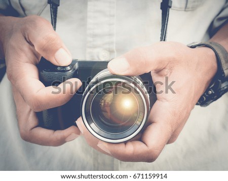Photographer holding mirorless camera with sunflare