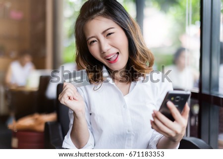business asian girl in white shirt with credit card and smartphone onine shopping ideas concept with background of blur image coffeeshop