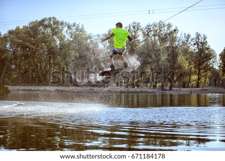Man is engaged in extreme sports, he jumps on the board on the water.