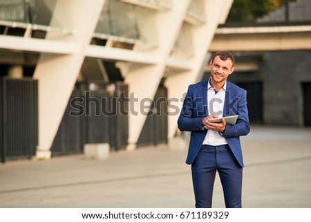 Businessman with tablet smiling. Happy young male outdoors. Easy steps to success.