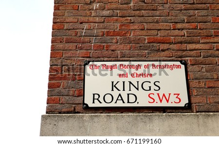 Kings Road: Colour photograph of street sign against red brick wall, Chelsea, London. 