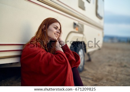 The woman is sitting by the old car                               