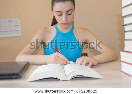 Young student Girl with lots of books studying for exams. Education concept