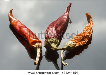Chili peppers with reflection in the glass surface