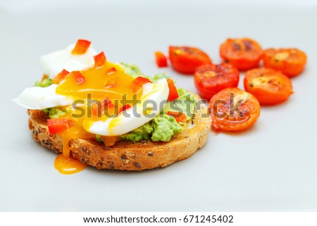 Picture of guacamole toast with boiled egg and cherry tomato on isolated background