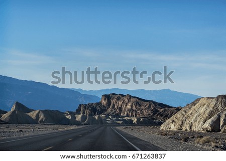 American road in Nevada from California to Las Vegas in the middle of Death Valley. Red rock mountains on the back
