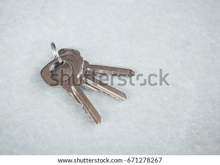 Bunch of keys lies on cement background.