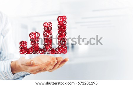 Close of hands holding in palms growing graph made of gears