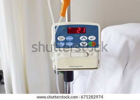 Infusion pump feeding IV drip in patient room in the hospital on blurred background. Royalty-Free Stock Photo #671282974