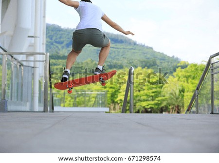 young woman skateboarder skateboarding at city