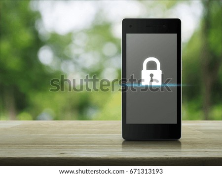 Key icon on modern smart phone screen on wooden table over blur green tree in park, Business internet security concept