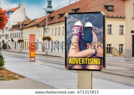 Billboard with advertising of a teenage girl with cellphone. At city street of Bratislava, while passing the tram, Slovakia