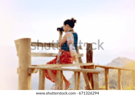 Blurred asian girl is shooting beautiful mountain scenery