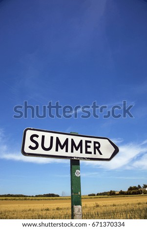 Road sign with the inscription summer, with a blue sky and a field in the background