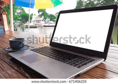 close up  laptop and coffee on wood table at near a river  