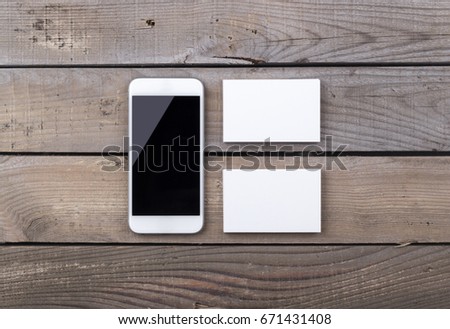 Photo of business cards with phone. Template with smart phone isolated on old wood background. For graphic designers presentations and portfolios damaged weathered antique mock-up with business cards