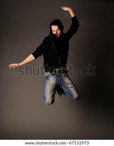 Young energy boy jumping against grey background
