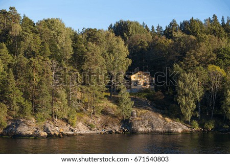 View on cottage in forest along Stockholm archipelago, Sweden. Summer sunset time.