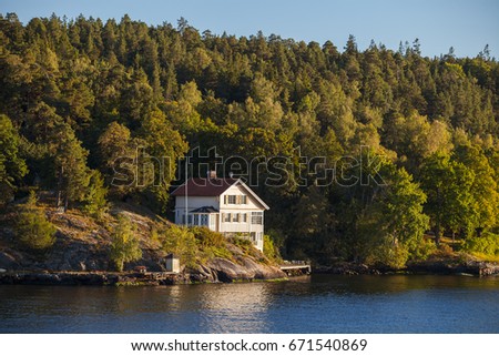 View on cottage in forest along Stockholm archipelago, Sweden. Summer sunset time.