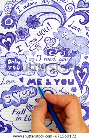 Woman hand with ballpoint pen draws love doodles messages on checkered paper.