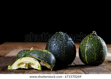 Tasty mini pumpkin on a wooden table, black background