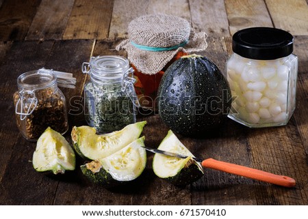 Pumpkin jars and spices. Preparations from your own garden. Wooden kitchen table. Black background.