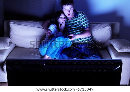 Couple on couch watching TV - shocked