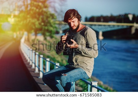 hipster man photographer is making landscape photography with retro old film camera medium format