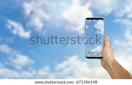 Tourist taking a picture of nature using a smartphone, point of view shot