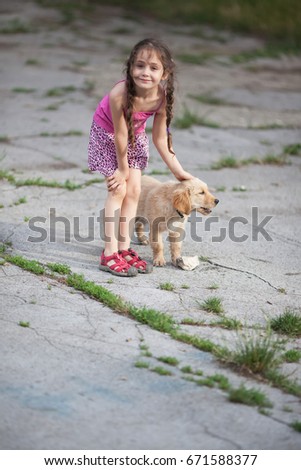Little girl is playing with a dog