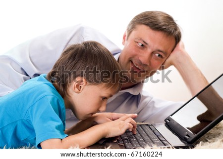 happy dad and son lying with laptop