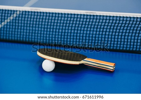 Table tennis racket and ball on blue table