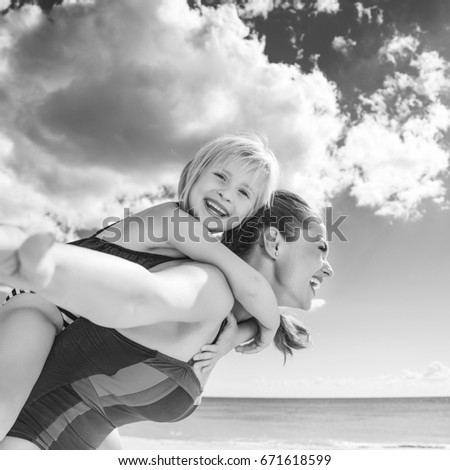 Sun kissed beauty. cheerful healthy mother and child in beachwear on the seacoast having fun time