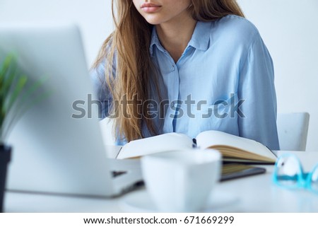 Beautiful young woman working at the computer in the office.