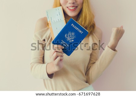 Portrait of a cheerful cute girl traveller in summer showing passport with tickets
